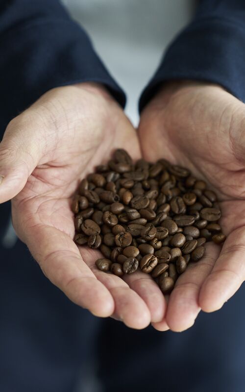 To kolleger taler sammen over en kop kaffe i uformelt kontormiljø