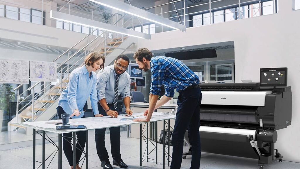 Team arbejder med storformatprint ved Canon printer i moderne kontormiljø